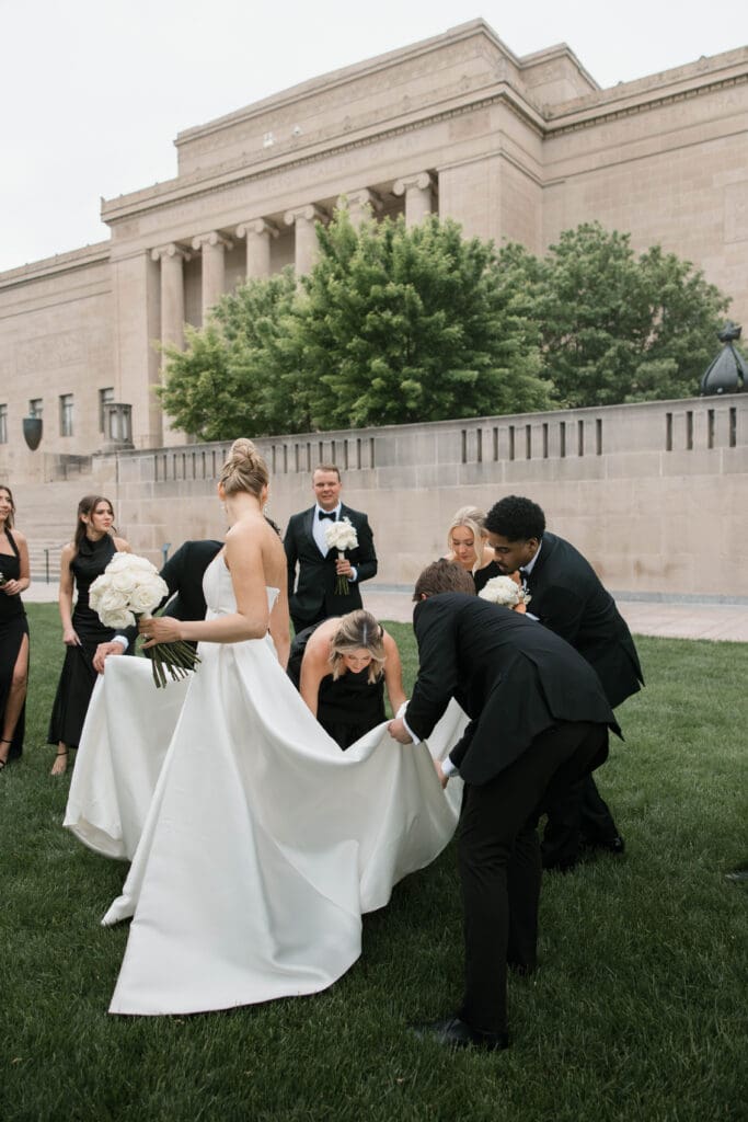 Wedding party laughing together on the museum lawn.