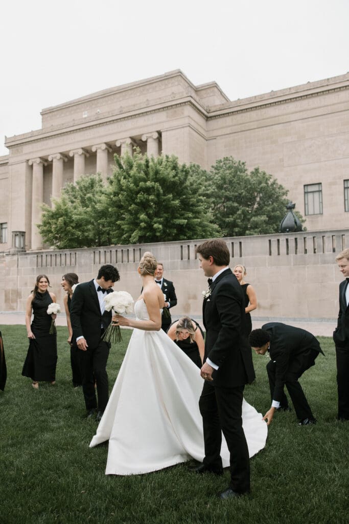 Wedding party laughing together on the museum lawn.