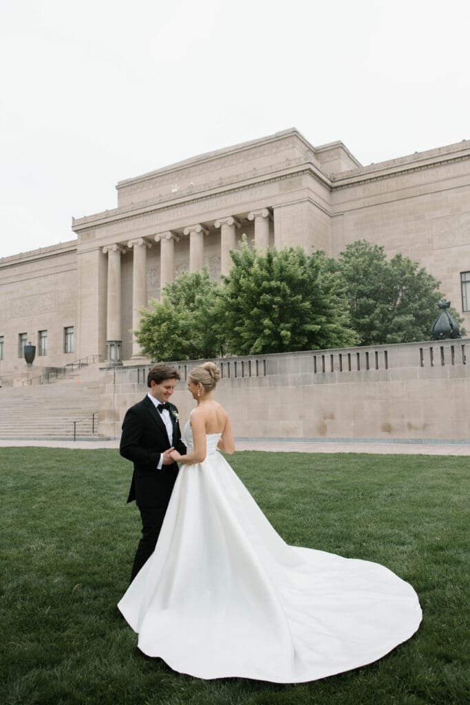 Bride and groom walking hand in hand at the Nelson-Atkins Museum of Art in Kansas City