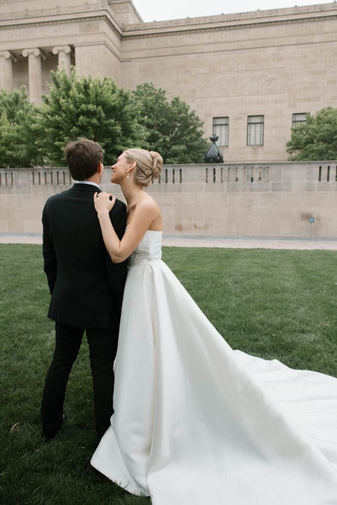 Bride and groom walking hand in hand at the Nelson-Atkins Museum of Art in Kansas City